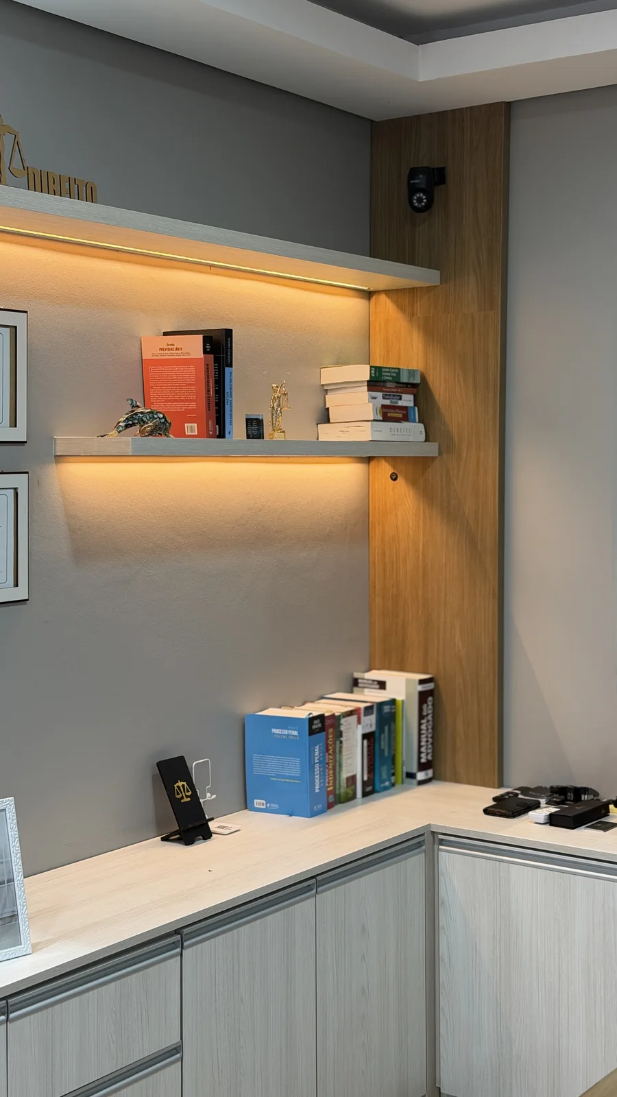 Sala de trabalho completa, com mesa, estantes e livros jurídicos
